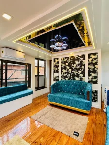 The fully enclosed air-conditioned front glass lounge with luxury sofa seating on the lower deck of the MITHRAM01 premium houseboat in Alleppey