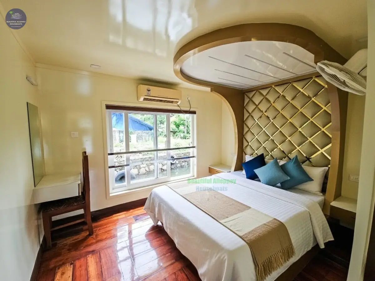 Premium AC Bedroom with Tufted Headboard – Luxury Houseboat Air-conditioned luxury houseboat bedroom featuring a double bed with a tall beige tufted headboard and large window.
