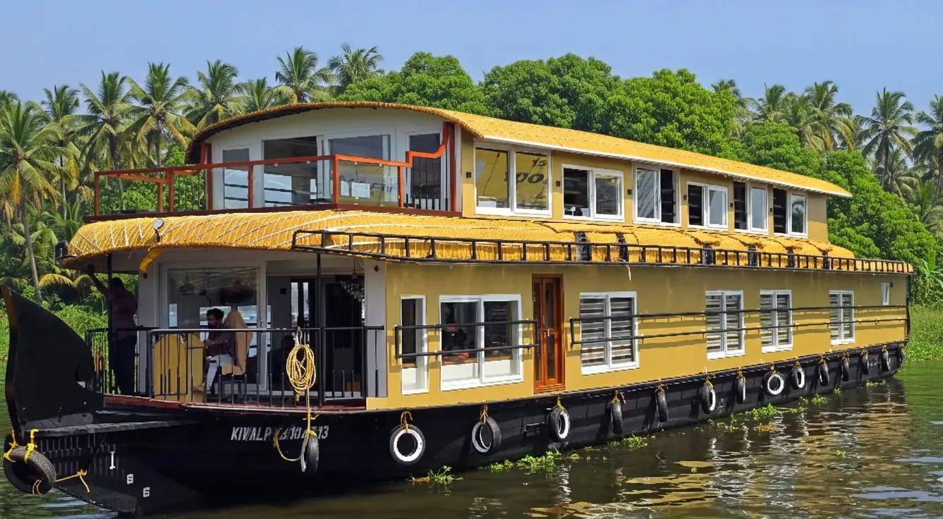 Full exterior view of a 4 bedroom premium luxury AC houseboat with an upper deck cruising on Alleppey backwaters in Kerala.