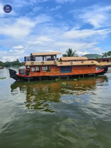 Exterior view of a premium 1-bedroom glass-covered houseboat cruising on Alleppey backwaters