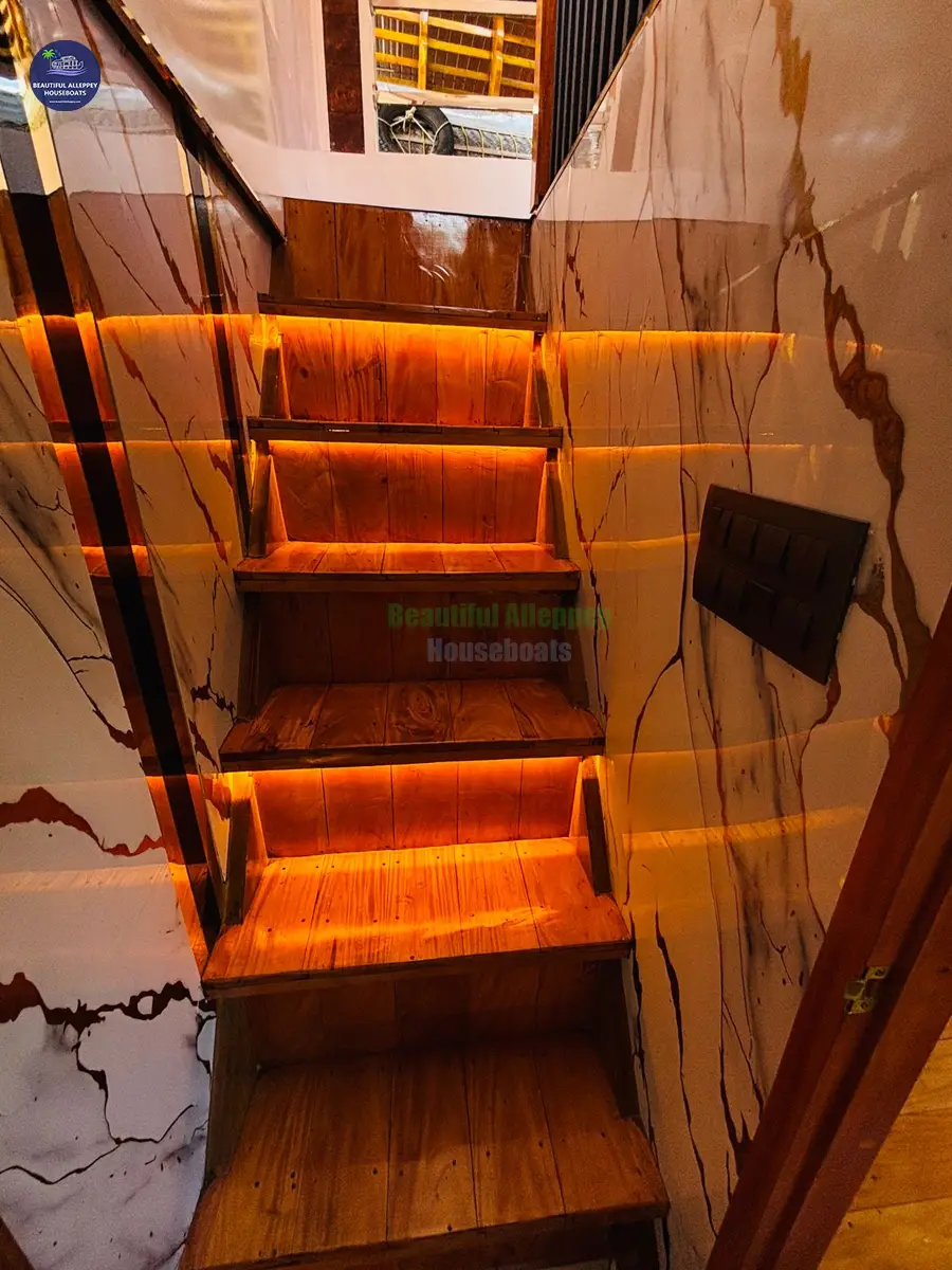 Staircase to Upper Deck Lounge Sleek wooden staircase with warm LED step lighting leading to the houseboat upper deck