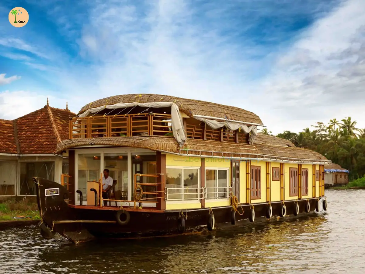 Exterior daytime view of the Paradise Three Bedroom Premium Houseboat RIV03 with an upper deck floating on serene backwaters.
