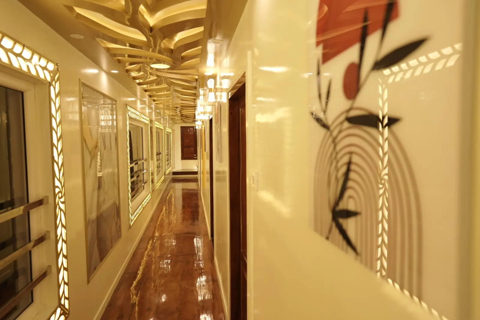 Side Deck Passage & Backwater View Walkway Side passage deck of a 5 bedroom luxury houseboat in Alleppey showing wooden flooring and open view of the water.