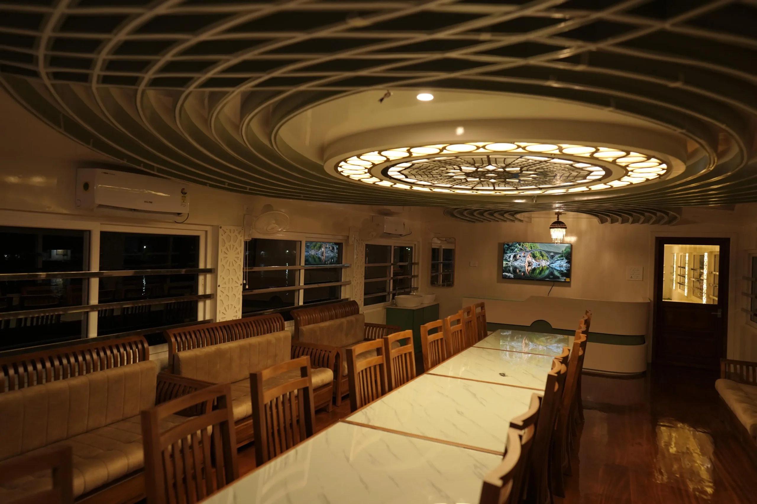 Expansive Upper Deck Lounge with Night LED Illumination Wide interior view of the spacious upper deck hall showing polished wooden floors and illuminated ambient ceiling lights at night.