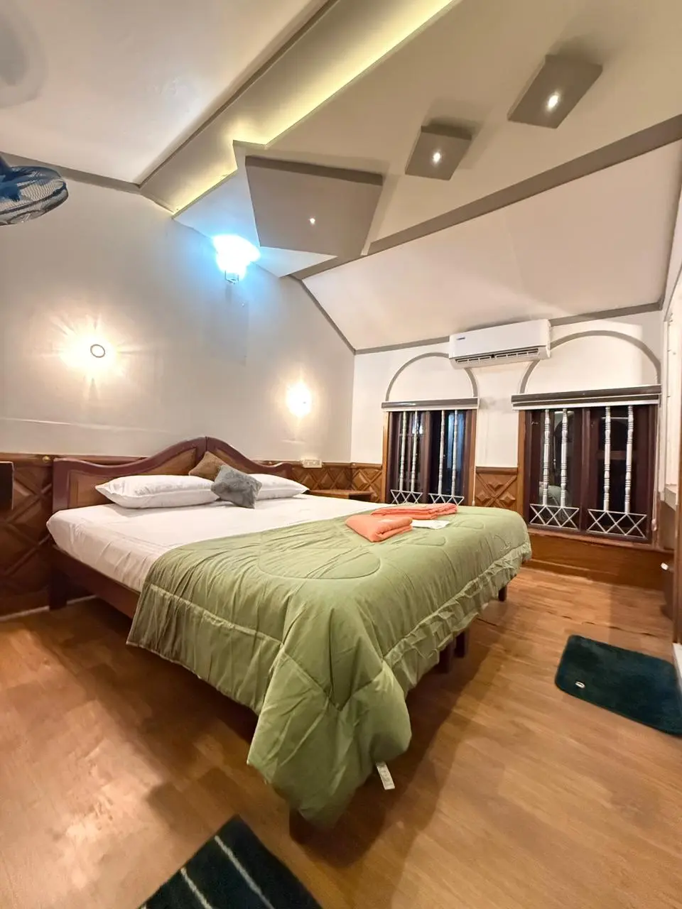 Second air-conditioned guest bedroom featuring traditional Kerala teak decor on Mithtam houseboat.